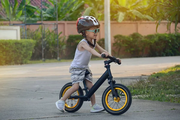 Счастливый Симпатичный Мальчик Носит Солнцезащитные Очки Спортивный Шлем Играя Велосипеде — стоковое фото