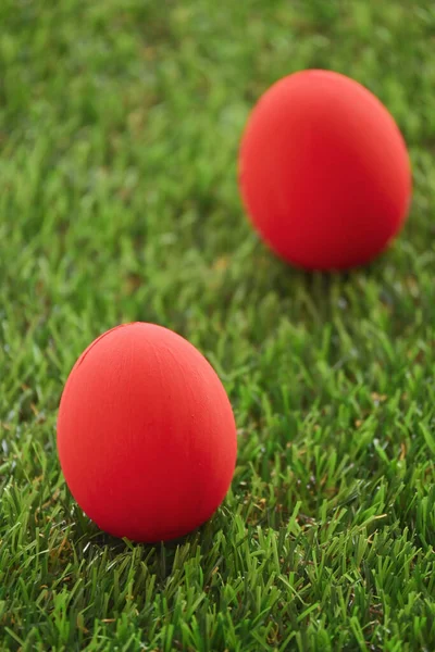 芝生の上の赤いイースターエッグ緑の芝生の人工的な朝の春のコンセプトのイメージ — ストック写真