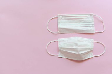 Pembe arka planda tıbbi yüz maskesi.
