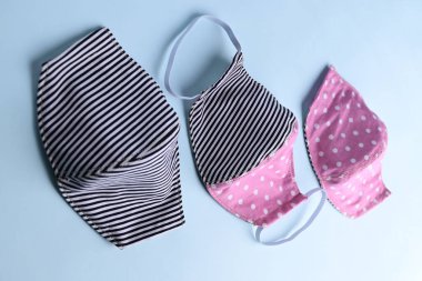 düz dizayn siyah ve pembe renkli moda yüz maskesi kumaştan el yapımı mavi arka plan