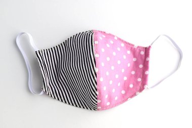 Beyaz arka planda izole edilmiş moda kumaşından yapılmış yüz maskesi el yapımı siyah ve pembe tasarım.