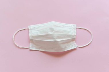 Pembe arka planda tıbbi yüz maskesi.