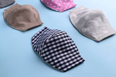 mavi arkaplandaki kumaştan el yapımı renkli moda maskesinin düz dizaynı