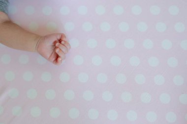 Pembe arka planda küçük bir bebek eli