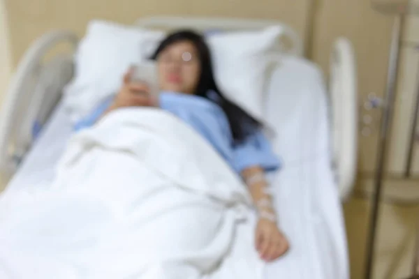 image blur of woman patient resting on bed inside recovery room in hospital