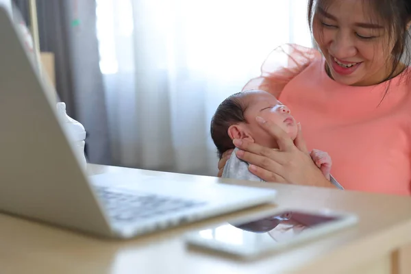 businesswoman parenting a little baby newborn in business home office, mother using hand help her son belch burping after breastfeeding milk