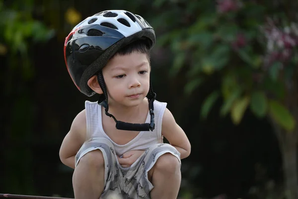 귀여운 아이는 공원에서 자전거를 스포츠 헬멧을 다닌다 — 스톡 사진
