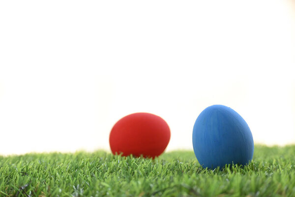 blue and red easter egg on lawn green grass artificial with blank white background