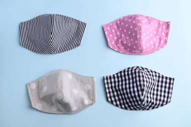 mavi arkaplandaki kumaştan el yapımı renkli moda maskesinin düz dizaynı