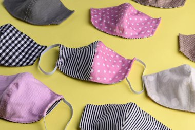 Renkli moda maskesinin düz dizaynı sarı arkaplanda kumaştan yapılmış el yapımı.