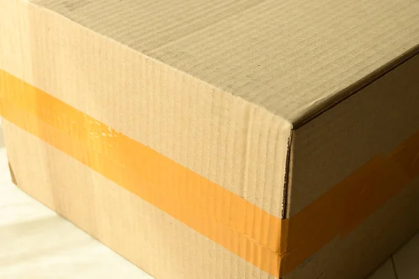 brown carton paper box package with packing scotch tape stick