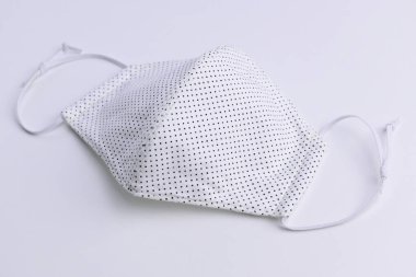 Moda kumaşından el yapımı yüz maskesi, beyaz arka planda pamuk kumaş.