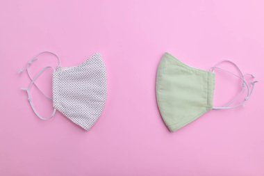 Beyaz ve yeşil yüz maskesi tasarımı. Moda kumaşından el yapımı. Pembe arka planda pamuk kumaş.