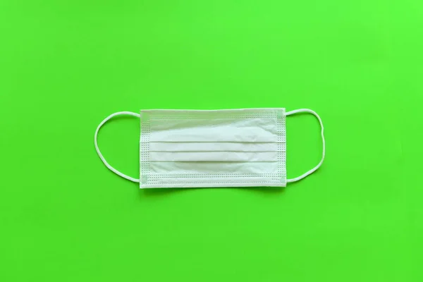 緑の背景に医療衛生面マスク — ストック写真