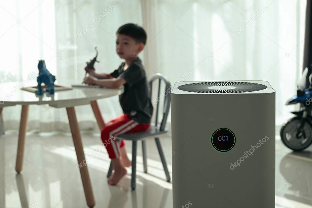 air purifier in living room with kid playing inside home