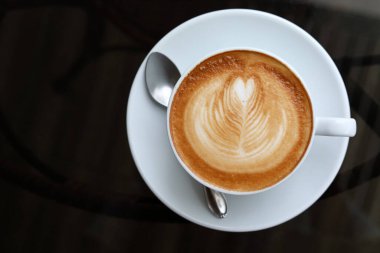 Kahve masasında sıcak latte içeceği var.