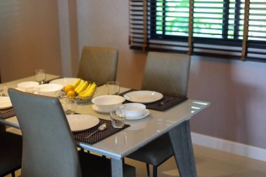 Çanak çömlek takımı yemek masasının üzerinde modern ev içi yemek odasının içinde.