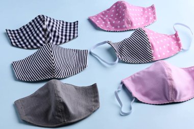 düz dizayn siyah ve pembe renkli moda yüz maskesi kumaştan el yapımı mavi arka plan