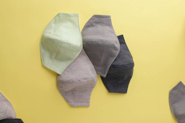 Kumaş pamuktan el yapımı moda maskesi tasarımı, sarı arkaplanda nesneler