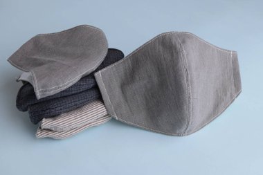 Mavi arka planda satılık kumaş pamuktan yapılmış el yapımı moda maskesi yığını.