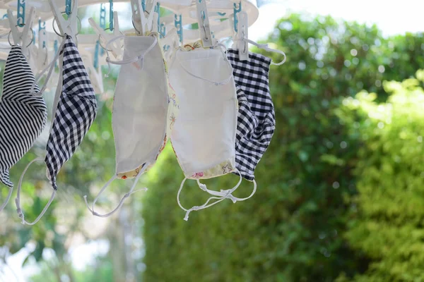 Temiz kumaş maskesini yıkamak, yeniden kullanmak için kuru dezenfektan asmak.