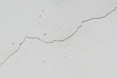 Yıpranmış arka planda eski beyaz duvarda çatlak var.