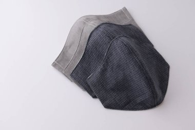 Satılık kumaş pamuktan el yapımı yüz maskesi yığını, beyaz arkaplanda izole nesneler