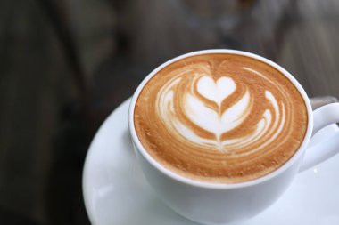 Kafe restoranında masaya konmuş sıcak latte kahve, sabah kahvaltısı.