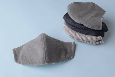 Mavi arka planda satılık kumaş pamuktan yapılmış el yapımı moda maskesi yığını.