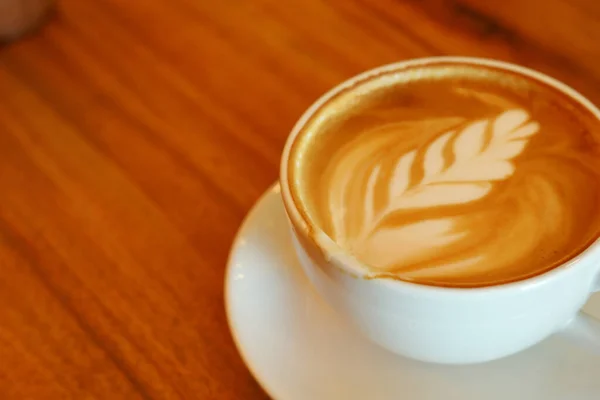 hot latte coffee put on wooden table in cafe restaurant