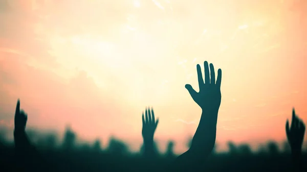 International migrants day concept: Silhouette many people raised hands over sunset background