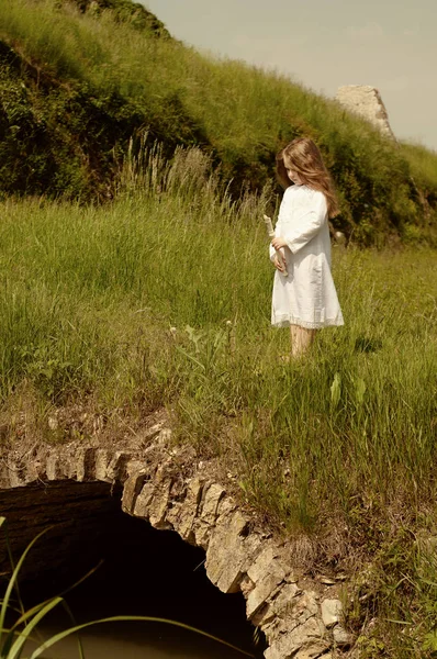 Niña con flauta blanca en el viejo puente de piedra —  Fotos de Stock