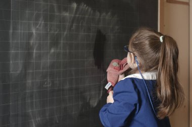 Italian first-grader cleaning the blackboard clipart