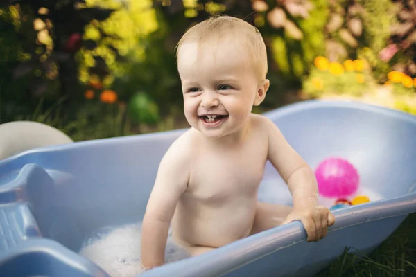 Улыбающийся ребенок в ванной на открытом воздухе — стоковое фото