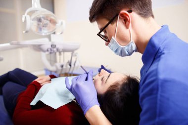 Genç erkek diş hekimi hastalar teeeth incelenmesi