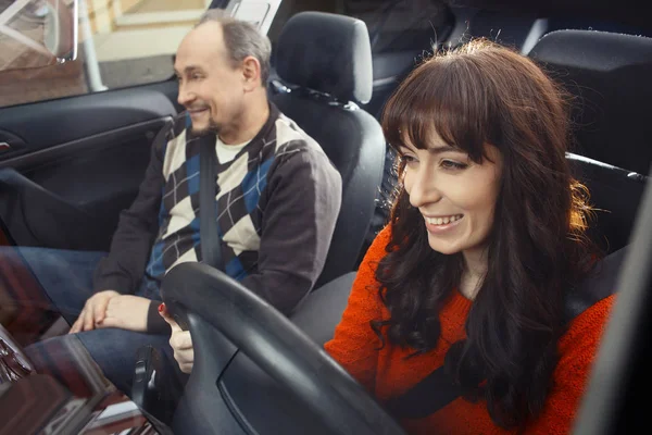 Genç kadını sürücüsü eğitmen yolcu koltuğu ile gülümseyen