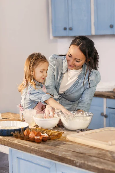 Smiling three years old girl trying to cook with her mother — Stock Photo, Image