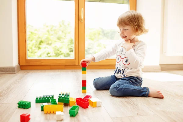 Маленькая Девочка Играет Пластиковыми Блоками Муке Возле Окна — стоковое фото