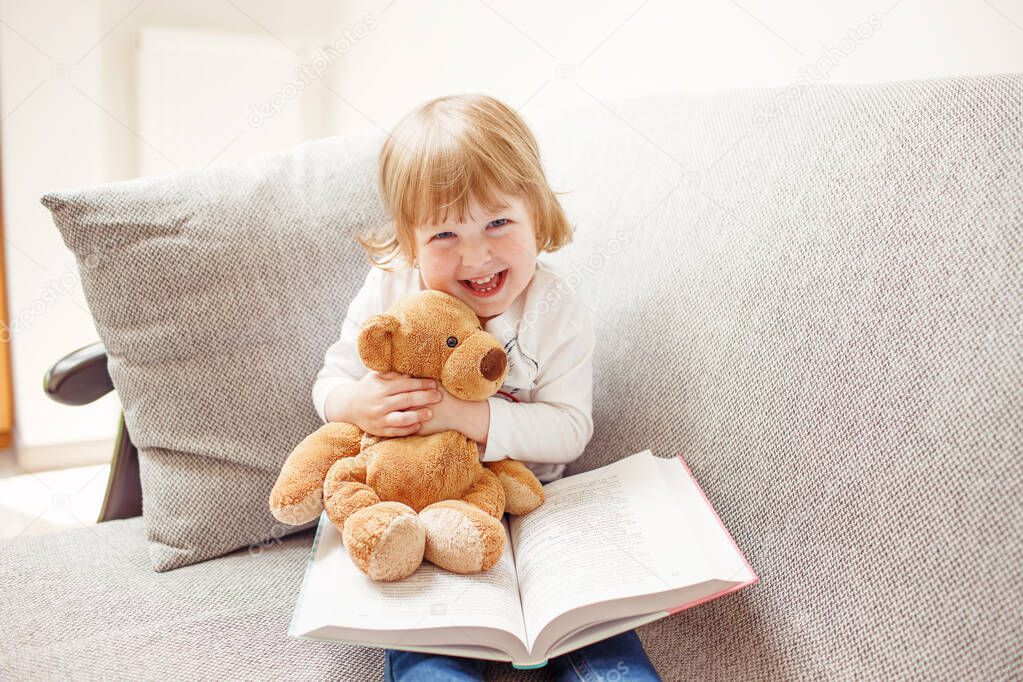 Smiling girl holding teddy bear
