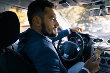 Arabada oturan kararlı genç bir adam.