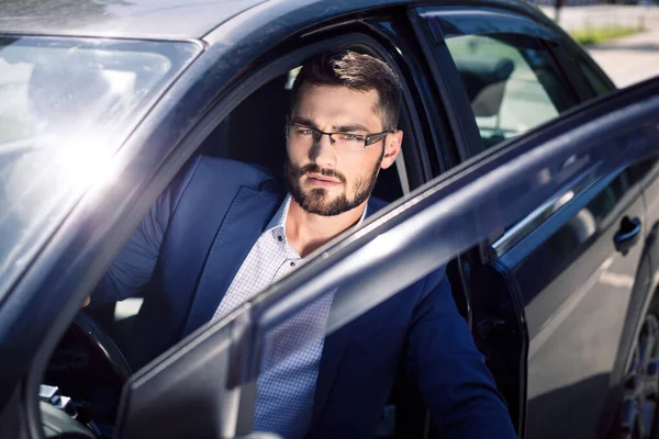 Arabadan çıkan yakışıklı genç adam.