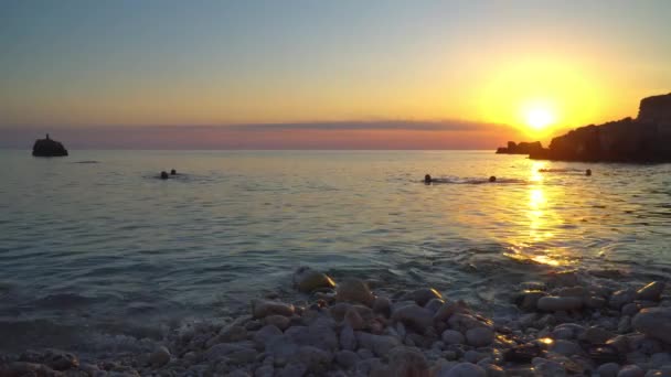 Le persone nuotano in mare al tramonto — Video Stock