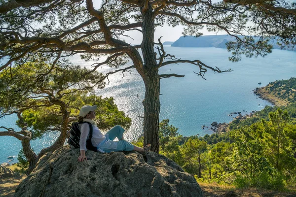 Touristin sitzt in Krimbergen am Meer — Stockfoto