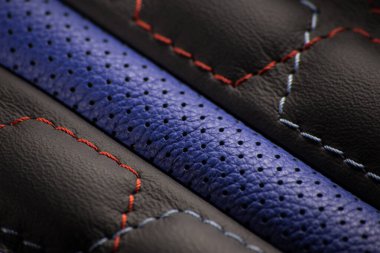 Deride kırmızı ve mavi iplikler ve mavi bir ekleme ile nakış.