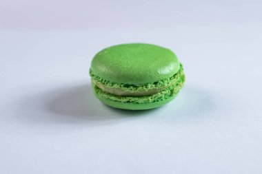 Beyaz arka planda fıstıklı ve kremalı yeşil makarna pastası.