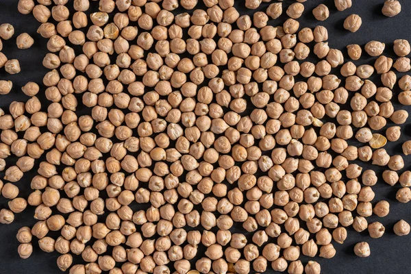 Siyah arka planda humus yapmak için bir sürü kuru nohut.