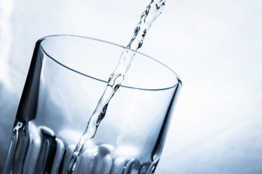 Beyaz arka planda şeffaf bir bardağa limonata dolduruyorum.