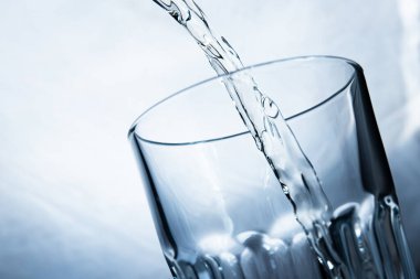 Beyaz arka planda şeffaf bir bardağa limonata dolduruyorum.