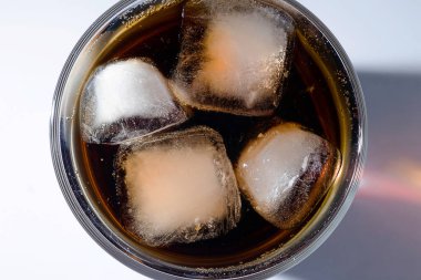 Şeffaf bardakta kola ve buzlu viski kokteyli.