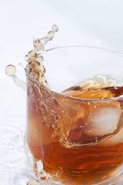 Kola ve buzlu viski kokteyli şeffaf bir bardakta güzel su damlalarıyla.